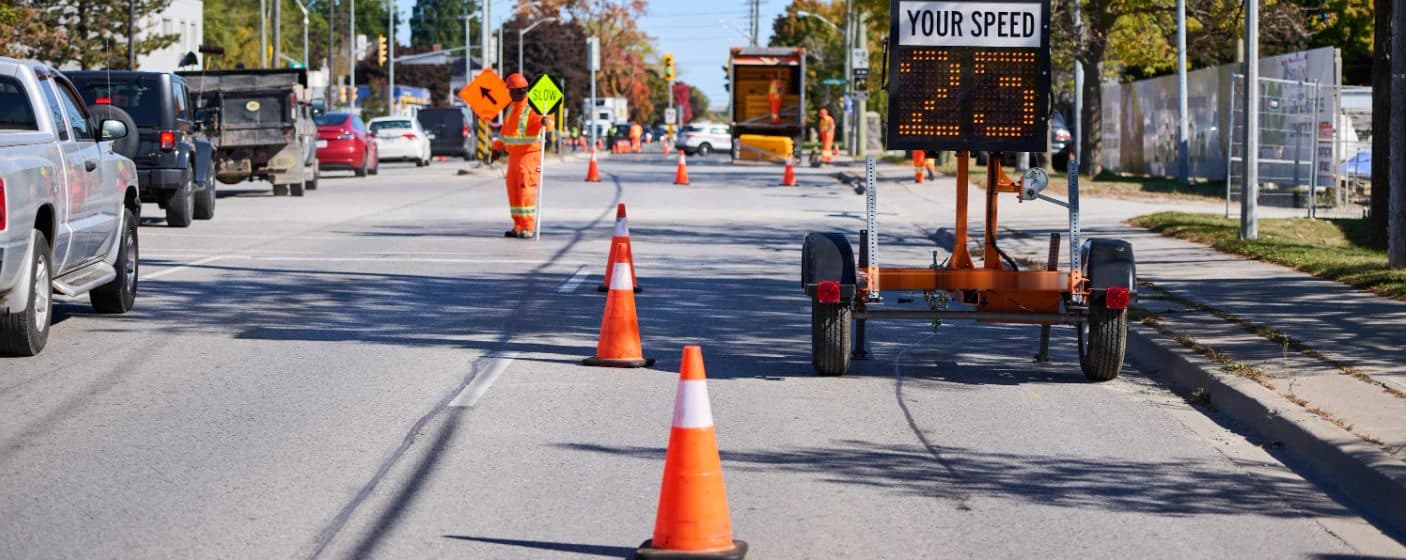 Traffic control person, cones and a speed trailer on a lane closure